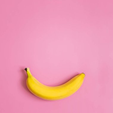 Pembe kare zemin üzerine bir, tek muz. Metin için yer. Minimalist kavramı.