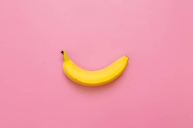 Pembe bir arka plan üzerinde bir, tek muz. Metin için yer. Minimalist kavramı.