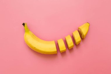 Muz, dilimleri, pastel pembe düzenlenmiş dices kesti. Metin için yer. Minimalist kavramı.