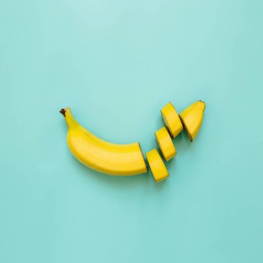 Muz, dilimleri, yeşil, mavi, ultramarine kare mavi zemin üzerine düzenlenmiş dices kesti. Metin için yer. Minimalist kavramı.