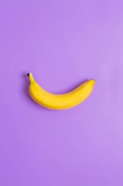 Bir, tek muz onpurple neon menekşe dikey arka plan. Metin için yer. Minimalist kavramı.