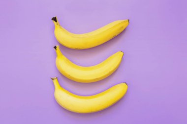 Mor neon arka plan satırındaki ağaç muz oluşur. Dikey kompozisyon. Minimalist kavramı.