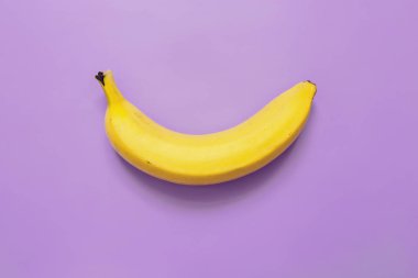 Mor neon menekşe arka plan üzerinde bir, tek muz. Metin için yer. Minimalist kavramı.