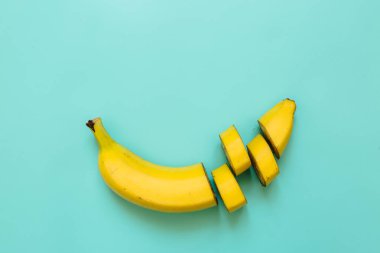 Muz, dilimleri, yeşil, mavi, ultramarine mavi zemin üzerine düzenlenmiş dices kesti. Metin için yer. Minimalist kavramı.