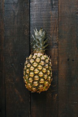 Olgun ananas koyu ahşap zemin üzerinde. Tropikal meyve yaratıcı kavramı. Alanın sığ deapth.