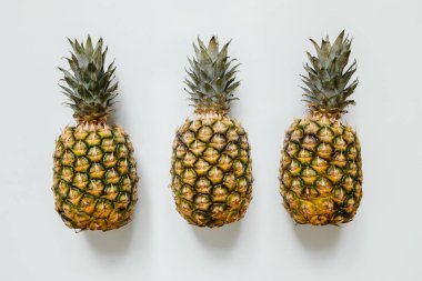 İzole beyaz arka plan üzerinde üç olgun ananas. Minimalist trendy tarzı kavramı.
