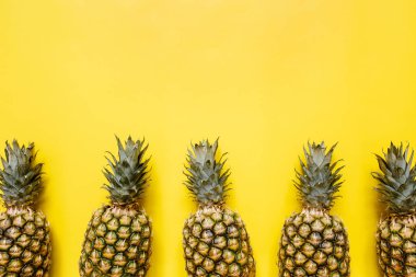 Olgun ananas sınır çerçeve izole canlı sarı zemin üzerine. Minimalist tarzı moda tropikal kavramı. Metin, kopyalama, yazı için boş alan.