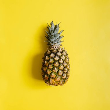 Olgun ananas izole canlı sarı zemin üzerine. Minimalist tarzı moda tropikal kavramı. Metin, kopyalama, yazı için oda.