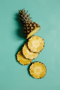 Olgun ananas Camgöbeği mavi, Turkuaz düz zemin üzerine dilimlenmiş.