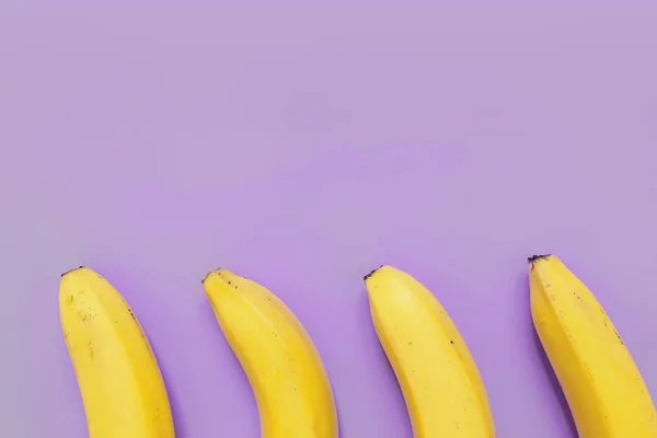 Чотири Банани Рамка Фіолетовому Неоновому Фіолетовому Фоні Порожній Простір Тексту — стокове фото