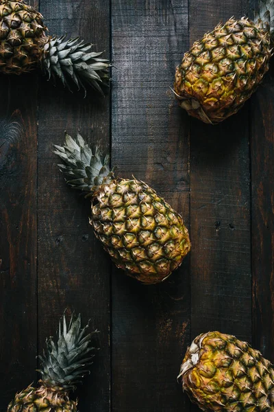 Koyu ahşap arka plan desen olgun ananas. Tropikal meyve yaratıcı kavramı.