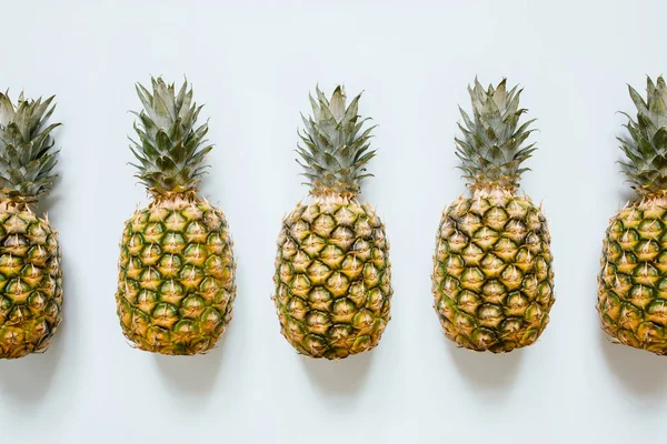 İzole beyaz arka plan üzerinde beş olgun ananas. Minimalist trendy tarzı kavramı.