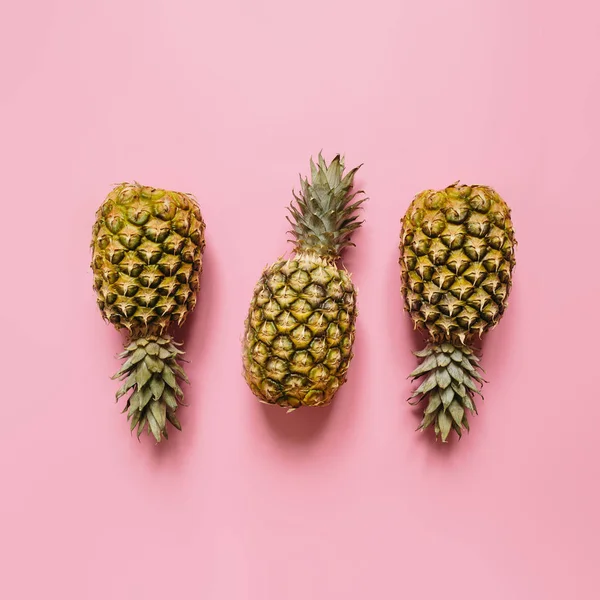 Ağaç izole soluk pembe arka plan üzerinde olgunlaşmış ananas. Minimalist tarzı moda tropikal kavramı.