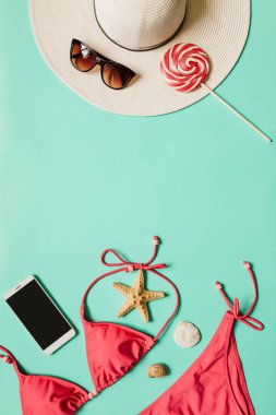 Kırmızı, pembe bikini takım, lolipop, güneş gözlüğü, smartphone, düz açık mavi renkli şapka. Kopyalama, metin, yazı için boş alanı. Dikey poster, afiş, kartpostal şablonu.