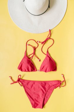 Akuamarin bikini mayo ve hasır şapka açık pembe renkli düzenlenmiştir. Minimalist tarzı yaratıcı kavramı.