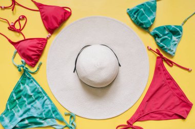 Akuamarin bikini mayo ve hasır şapka açık pembe renkli düzenlenmiştir. Minimalist tarzı yaratıcı kavramı.