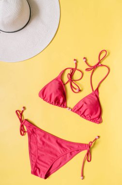 Akuamarin bikini mayo ve hasır şapka açık pembe renkli düzenlenmiştir. Minimalist tarzı yaratıcı kavramı.