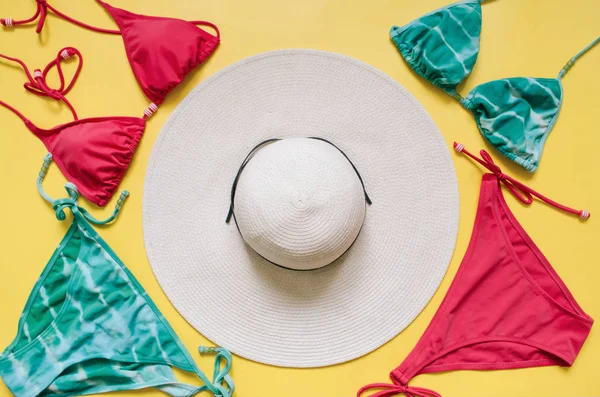 Akuamarin bikini mayo ve hasır şapka açık pembe renkli düzenlenmiştir. Minimalist tarzı yaratıcı kavramı.