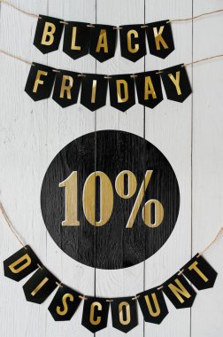 Beyaz barn tahtaya asılı harflerle siyah Cuma on yüzde indirim Kağıt afiş garland arka plan plakalar. Dikey tatil lüks el ilanı.