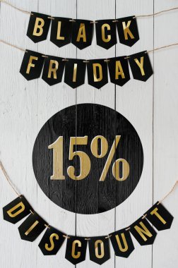 Beyaz barn tahtaya asılı harflerle siyah Cuma on beş yüzde indirim Kağıt afiş garland arka plan plakalar. Dikey tatil lüks el ilanı.