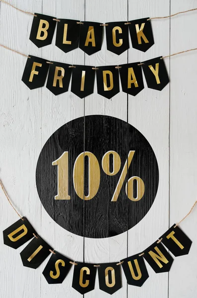 Beyaz barn tahtaya asılı harflerle siyah Cuma on yüzde indirim Kağıt afiş garland arka plan plakalar. Dikey tatil lüks el ilanı.