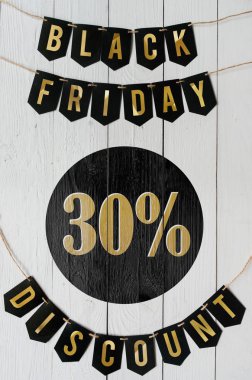 Beyaz barn tahtaya asılı harflerle siyah Cuma otuz yüzde indirim Kağıt afiş garland arka plan plakalar. Dikey tatil lüks el ilanı.