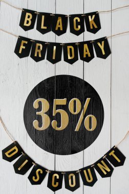Cuma yüzde otuz beş indirim Kağıt afiş garland beyaz barn tahtaya asılı yazı plakalar arka plan siyah. Güzel dikey tatil el ilanı.