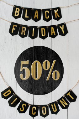 Beyaz barn tahtaya asılı harflerle siyah Cuma elli yüzde indirim Kağıt afiş garland arka plan plakalar. Güzel dikey tatil el ilanı.