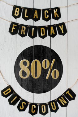 Beyaz barn tahtaya asılı harflerle siyah Cuma seksen yüzde indirim Kağıt afiş garland arka plan plakalar. Dikey tatil lüks el ilanı.