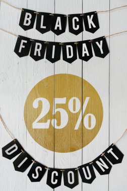 Cuma yirmi beş yüzde indirim Kağıt afiş garland beyaz barn tahtaya asılı yazı plakalar arka plan siyah. Dikey tatil lüks el ilanı.