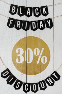 Beyaz barn tahtaya asılı harflerle siyah Cuma otuz yüzde indirim Kağıt afiş garland arka plan plakalar. Dikey tatil lüks el ilanı.