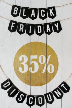 Cuma yüzde otuz beş indirim Kağıt afiş garland beyaz barn tahtaya asılı yazı plakalar arka plan siyah. Güzel dikey tatil el ilanı.