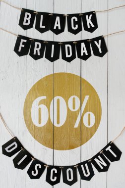 Beyaz barn tahtaya asılı harflerle siyah Cuma altmış yüzde indirim Kağıt afiş garland arka plan plakalar. Dikey tatil lüks el ilanı.