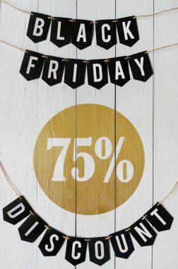 Cuma yüzde yetmiş beş indirim Kağıt afiş garland beyaz barn tahtaya asılı yazı plakalar arka plan siyah. Güzel dikey tatil el ilanı.