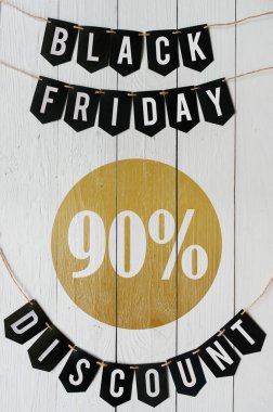 Beyaz barn tahtaya asılı harflerle siyah Cuma doksan yüzde indirim Kağıt afiş garland arka plan plakalar. Lüks dikey alışveriş el ilanı.