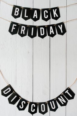 Beyaz barn ahşap plakalar arka plan üzerinde asılı harflerle siyah Cuma indirim Kağıt afiş garland. Güzel tatil kartpostal dikey şablonu. Metin için boş yer.