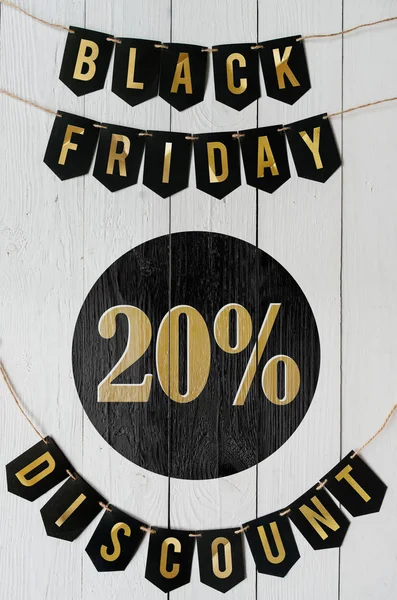 Beyaz barn tahtaya asılı harflerle siyah Cuma yirmi yüzde indirim Kağıt afiş garland arka plan plakalar. Çarpıcı dikey tatil el ilanı.