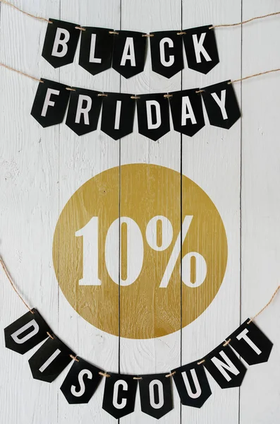 Beyaz barn tahtaya asılı harflerle siyah Cuma on yüzde indirim Kağıt afiş garland arka plan plakalar. Dikey tatil lüks el ilanı.