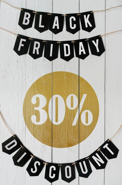 Beyaz barn tahtaya asılı harflerle siyah Cuma otuz yüzde indirim Kağıt afiş garland arka plan plakalar. Dikey tatil lüks el ilanı.