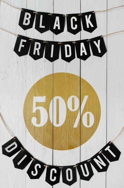 Beyaz barn tahtaya asılı harflerle siyah Cuma elli yüzde indirim Kağıt afiş garland arka plan plakalar. Güzel dikey tatil el ilanı.