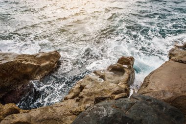 Detaylı turkuaz deniz su desenle dalgalar ve köpük sarı taş yakınındaki. Hareketli arka plan.