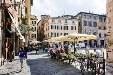 Lucca, İtalya - 5 Ekim 2017: İnsanlar eski ortaçağ kenti sokaklarında. Tipik turistik şehir hayatı sahne.