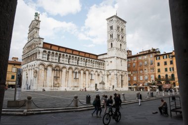 Lucca, İtalya - 5 Ekim 2017: İnsanlar yürüyüş Chiesa di önünde kare San Michele Foro içinde kilise şehir merkezinde.