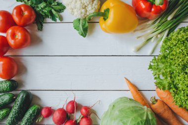 Sağlıklı gıda kavramı. Sebze salatası malzemeler sınır çerçeve. Beyaz ahşap rustik kırsal masa boş alan arka plan. Organik düz poster şablonu düzenleme.