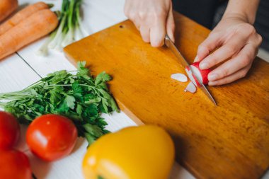 Kesme taze kırmızı organik turp ahşap pano portre üzerinde eller kadın. Beyaz tablo arka planı.