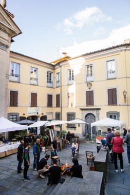 Barga, İtalya - 8 Ekim 2017: Yerel halkın kestane kızartma, şarap içmek ve küçük turistik Antik Ortaçağ kenti, Lucca, Toskana meydanında akşamın tadını çıkar,