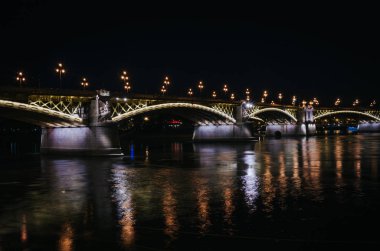 Margaret köprüsünün gece görüşü güzelce aydınlatılmış, Macaristan 'ın Budapeşte kentindeki Tuna Nehri' nde ışık yansımaları