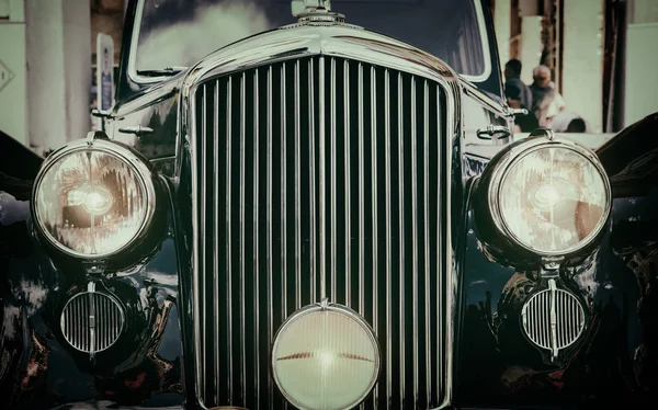 Front view of classic vintage car. Retro toned postcard, poster.