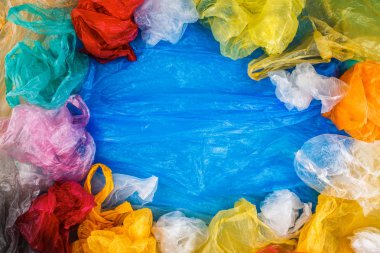 Çok renkli plastik torbalar sınır çerçeve mavi zemin üzerine. Kopyalama, metin, yazı için boş alanı. Yaratıcı çevre poster şablonu. Evde beslenen hayvan çanta koleksiyonu kavramı.