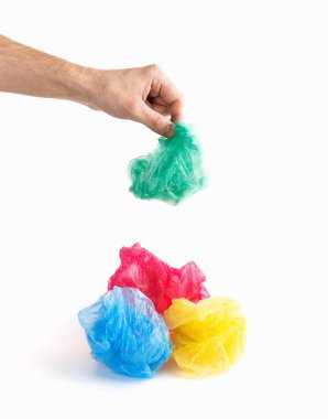 Mavi, kırmızı ve sarı üzerinde yeşil polietilen tutan erkek el plastik torba birlikte izole beyaz arka plan üzerinde buruşuk. Kopyalama, metin, yazı için boş alanı. Kare ekolojik poster şablonu. Çevre plastik kirliliği kavramı.